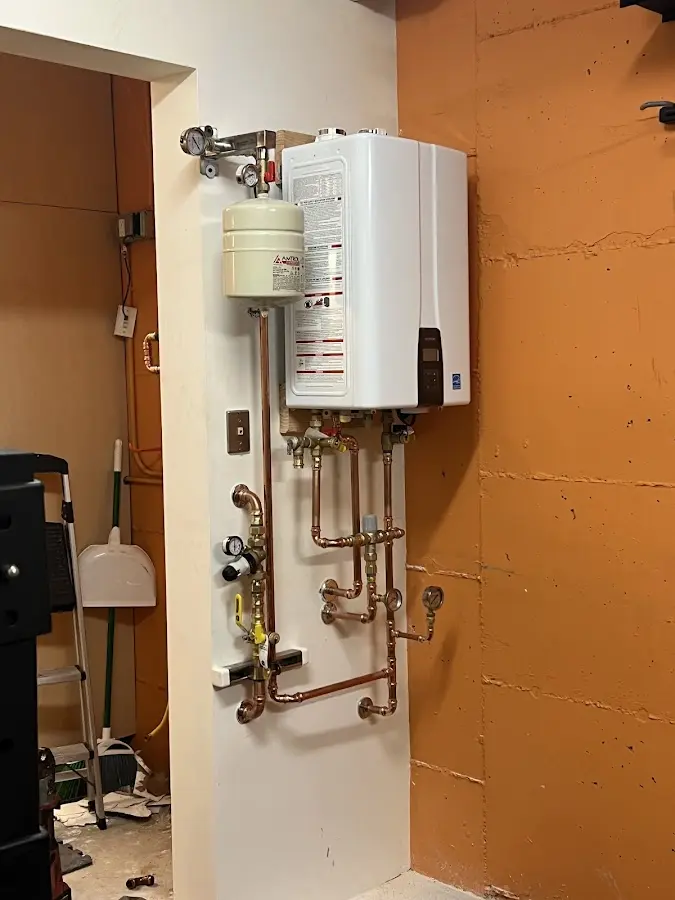 Plumbing technician inspecting water heater connections in Wills Point